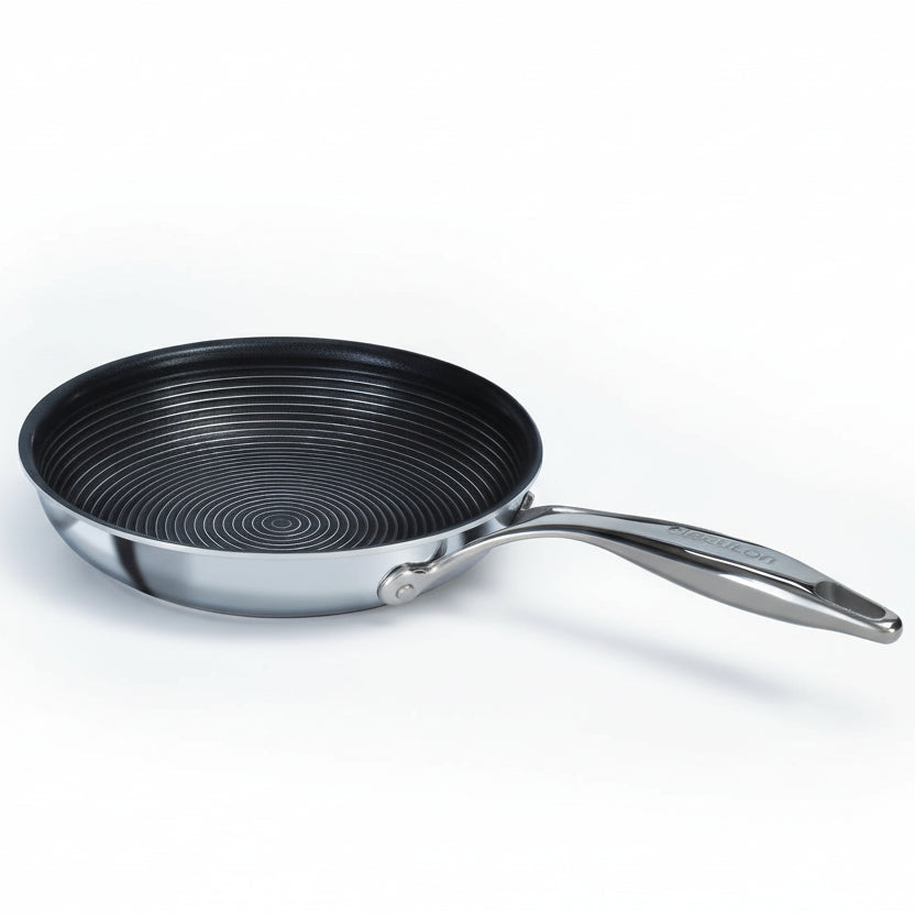 Frying pan with a black interior and silver exterior on a white background